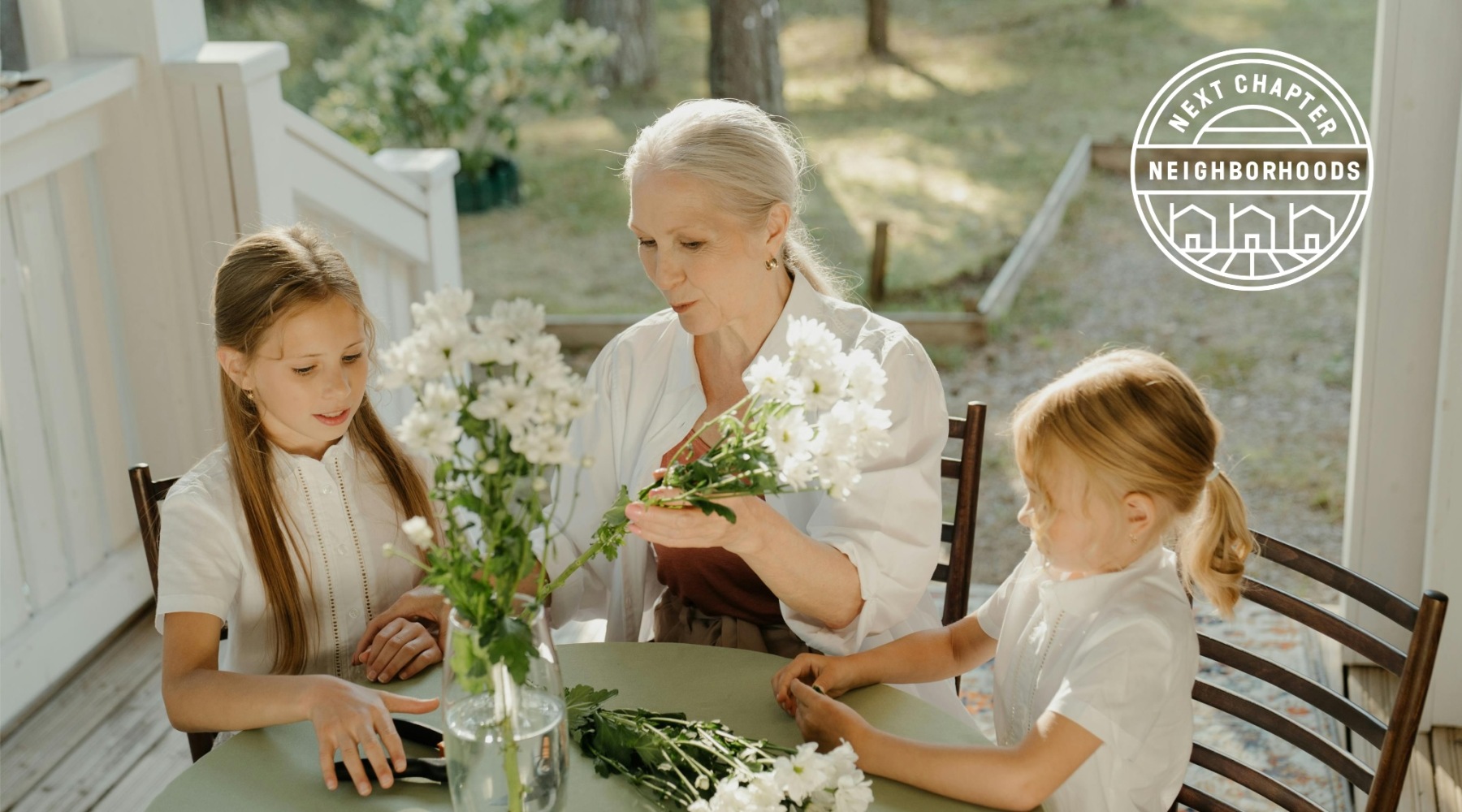 a grandmother figure and two children preparing flowers in a bright area